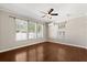 Cozy bedroom with hardwood floors, three large windows for ample natural light, and a ceiling fan at 780 Old Mount Dora Rd, Eustis, FL 32726