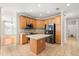 Kitchen with stainless steel appliances, tiled flooring, an island, and wooden cabinetry at 780 Old Mount Dora Rd, Eustis, FL 32726