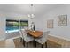 Dining room features a wooden table and view of the backyard pool through a sliding glass door at 822 Swaying Palm Dr, Apopka, FL 32712