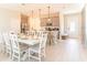 Dining area open to kitchen with a large dining table, white chairs, and modern pendant lighting at 844 Driving Range Ct, Reunion, FL 34747