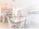 Dining area open to the kitchen with a modern table, white chairs, and contemporary pendant lights at 844 Driving Range Ct, Reunion, FL 34747