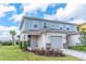 Two-story home with a one car garage, stone veneer accents, and neatly manicured landscaping at 844 Driving Range Ct, Reunion, FL 34747