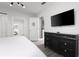 This bedroom features a black dresser with lots of storage and a wall mounted tv and a view of the hallway at 9033 Hazard St, Davenport, FL 33896