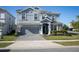 Beautiful two-story home featuring a paved driveway, a two-car garage, and well-maintained landscaping at 9033 Hazard St, Davenport, FL 33896