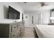 This bright main bedroom has sleek flooring, a large dresser, and an ensuite bathroom at 9033 Hazard St, Davenport, FL 33896