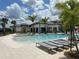 Relaxing poolside scene with lounge chairs and palm trees under a sunny sky at 9033 Hazard St, Davenport, FL 33896