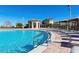 Expansive pool with deck chairs overlooking a luxurious clubhouse on a sunny day at 9033 Hazard St, Davenport, FL 33896