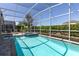 A screened in private pool with a jacuzzi offers sun loungers and privacy from the perimeter hedges at 9033 Hazard St, Davenport, FL 33896