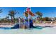 Community water park featuring a slide and splash bucket, surrounded by loungers and palm trees at 9033 Hazard St, Davenport, FL 33896