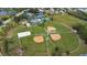 Aerial view of community featuring baseball fields, tennis courts, lake and recreational facilities at 908 Jade Forest Ave, Orlando, FL 32828