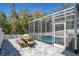 Outdoor dining set on a paved patio next to a screened pool enclosure and lush foliage at 908 Jade Forest Ave, Orlando, FL 32828