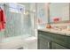 Cozy bathroom with modern vanity, granite countertops, decorative mirror, and mosaic tiled shower at 908 Jade Forest Ave, Orlando, FL 32828