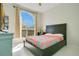 Comfortable bedroom featuring a large window and a wooden-framed bed with bright patterned bedding at 908 Jade Forest Ave, Orlando, FL 32828