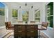 Bright breakfast nook with a marble countertop island, stylish pendant lights, and multiple windows at 908 Jade Forest Ave, Orlando, FL 32828