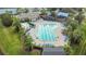 Aerial view of the community pool with lounge chairs, umbrellas and surrounded by lush landscaping and palm trees at 908 Jade Forest Ave, Orlando, FL 32828