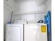 Functional laundry area with washer, dryer, and wire shelving for convenient storage solutions at 1017 S Hiawassee Rd # 3735, Orlando, FL 32835