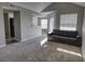Sun-filled living room featuring grey sofa and open view to kitchen and dining area at 1017 S Hiawassee Rd # 3735, Orlando, FL 32835