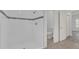 Modern bathroom featuring white-tiled shower and toilet, leading to a hallway at 12781 Sw 86Th Circle, Ocala, FL 34473