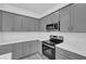 Modern kitchen featuring grey cabinets, stainless steel appliances, and white countertops at 12781 Sw 86Th Circle, Ocala, FL 34473