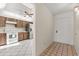 Hallway leading into the kitchen, featuring white appliances and wooden cabinets at 15 Escondido Ct # 145, Altamonte Springs, FL 32701