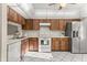 Kitchen with white tile floor, stainless steel appliances and wood cabinets at 15 Escondido Ct # 145, Altamonte Springs, FL 32701