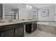 Bathroom features double sink, marble tub, glass shower, and modern fixtures at 1565 Mulligan Blvd, Davenport, FL 33896