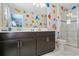 Spacious bathroom with a double sink vanity, a stylish mirror, and a glass-enclosed shower at 1565 Mulligan Blvd, Davenport, FL 33896
