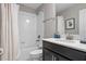 Bathroom features white tile, dark cabinets, framed mirror, and combination shower and bathtub at 1565 Mulligan Blvd, Davenport, FL 33896