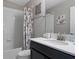 Bathroom features white tile, dark cabinets, framed mirror, and combination shower and bathtub at 1565 Mulligan Blvd, Davenport, FL 33896