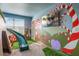 Whimsical bedroom featuring a custom-painted mural, a slide, and a built-in play area at 1565 Mulligan Blvd, Davenport, FL 33896
