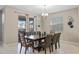 Spacious dining room with a stylish light fixture and sliding glass doors leading to a screened patio at 1565 Mulligan Blvd, Davenport, FL 33896
