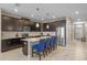 Modern kitchen with dark cabinetry, a large island with bar seating, and stainless steel appliances at 1565 Mulligan Blvd, Davenport, FL 33896