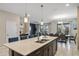 Open concept kitchen with quartz countertops, stainless steel appliances, and island with barstools at 1565 Mulligan Blvd, Davenport, FL 33896