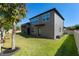 A spacious backyard featuring a lush green lawn, the grey house and fence at 16003 Tangerine Blossom Way, Winter Garden, FL 34787