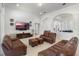 Bright living room with brown leather sofas and ottomans, plus lots of natural light and modern decor at 16003 Tangerine Blossom Way, Winter Garden, FL 34787
