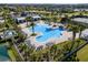 Aerial view of a community pool with ample lounge seating and lush palm trees in a resort-style setting at 16003 Tangerine Blossom Way, Winter Garden, FL 34787