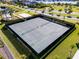 Aerial view of community tennis courts surrounded by lush grass, a lake, and well manicured greenery at 16003 Tangerine Blossom Way, Winter Garden, FL 34787