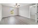Bright bedroom with laminate floors, ceiling fan and a large window overlooking a green landscape at 177 Larch Rd, Ocala, FL 34480