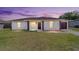 Charming single-Gathering home with a well-manicured lawn, a driveway, and inviting curb appeal during dusk at 177 Larch Rd, Ocala, FL 34480