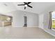 Bright living room showcasing neutral paint, tile floors, and a ceiling fan, leading into an open kitchen at 177 Larch Rd, Ocala, FL 34480