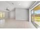 Spacious living room with tile flooring, ceiling fan, and sliding door to backyard, perfect for relaxation at 177 Larch Rd, Ocala, FL 34480