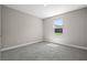 This bedroom features gray carpet and a bright window, providing ample natural light at 18 Pine Pass Ln, Ocala, FL 34472