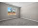 This bedroom has light colored walls, gray carpet, and a bright window overlooking the backyard at 18 Pine Pass Ln, Ocala, FL 34472