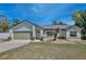 Charming single-story home featuring a well-manicured lawn, attached garage, and inviting front entrance at 209 Roman Ct, Deltona, FL 32738