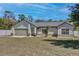Attractive single-story home showcasing a well-maintained lawn and a front yard with mature tree at 209 Roman Ct, Deltona, FL 32738