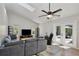 Bright living room features a skylight, ceiling fan, and access to the outdoor patio at 209 Roman Ct, Deltona, FL 32738