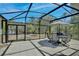 Screened patio featuring an outdoor dining set, providing a comfortable space for enjoying the lake view at 209 Roman Ct, Deltona, FL 32738