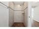 Updated shower with tile surround, wood-look tile floors, and modern fixtures at 2318 Vincent Rd, Orlando, FL 32817