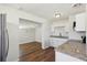 Kitchen features granite countertops, white cabinets, stainless steel appliances, and wood-look floors at 2318 Vincent Rd, Orlando, FL 32817