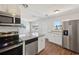 Updated kitchen boasts stainless steel appliances, granite countertops, white cabinetry and wood-look flooring at 2318 Vincent Rd, Orlando, FL 32817